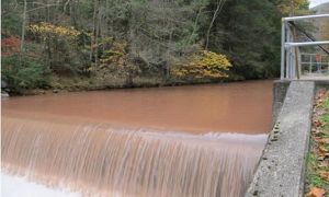 Muddy, brown water rushes down a stream. Image: Brantley, S. (2014, April 9)